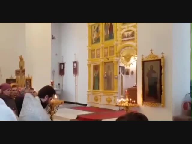 Батюшка поливает из шланга