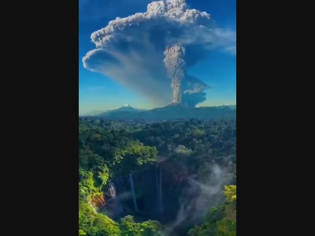 Извержение вулкана Семеру на фоне водопада