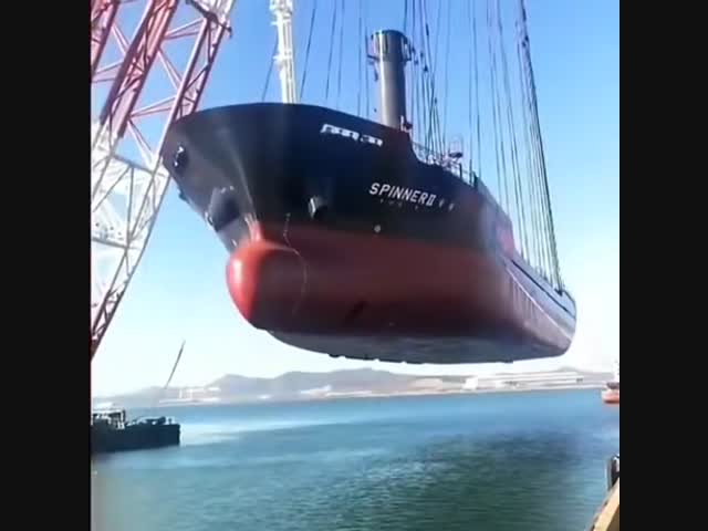 Самый большой плавучий кран в мире переносит судно.