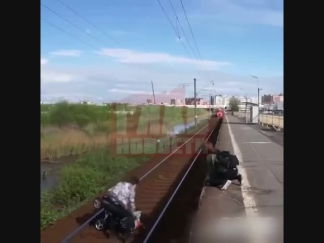 Парень, рискуя жизнью спас коляску с ребенком, скатившуюся под поезд