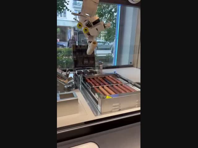 Робот готовит булочку с сосиской