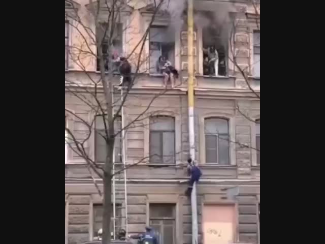 В Петербурге дворник ловко залез по водосточной трубе на 3 этаж для спасения девушек из горящих квартир