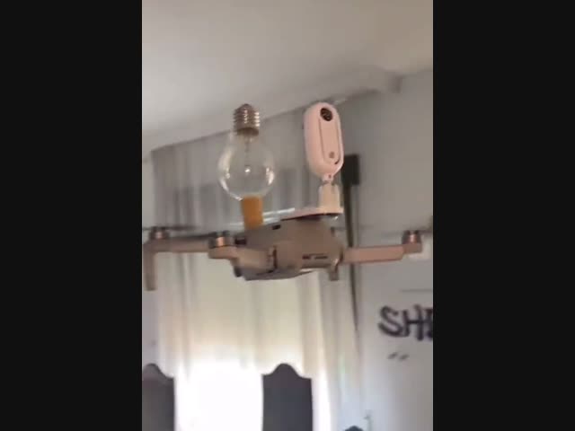 Дрон вкручивает лампочку в патрон